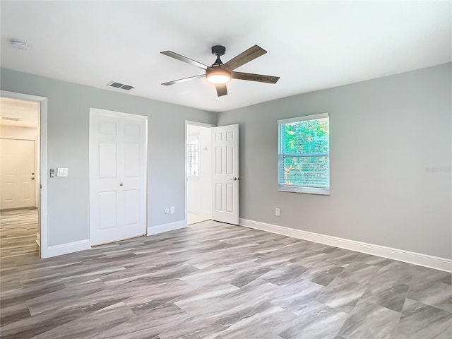 unfurnished bedroom with ceiling fan and a closet