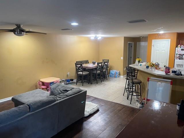 living room featuring light hardwood / wood-style floors and ceiling fan