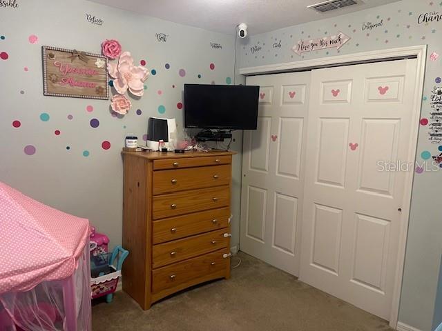 carpeted bedroom with a closet