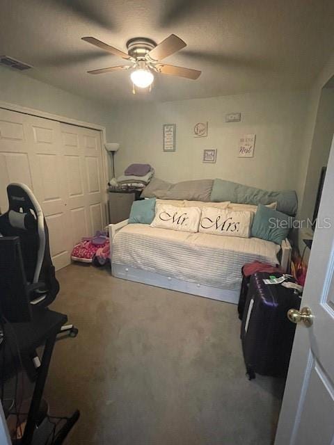 carpeted bedroom featuring ceiling fan and a closet