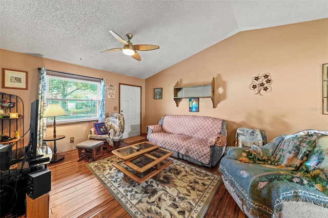 living room with ceiling fan, lofted ceiling, wood-type flooring, and a textured ceiling