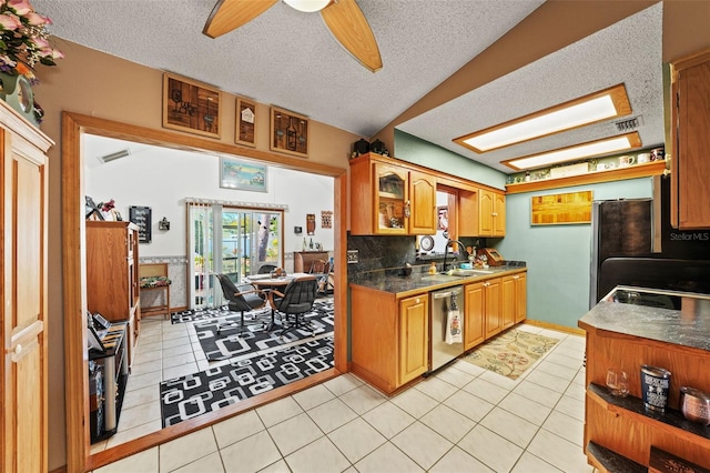 kitchen with sink, stainless steel dishwasher, light tile patterned floors, ceiling fan, and a textured ceiling