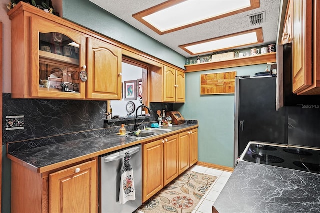 kitchen with appliances with stainless steel finishes, sink, decorative backsplash, light tile patterned floors, and a textured ceiling