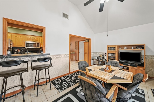 tiled dining room featuring high vaulted ceiling and ceiling fan