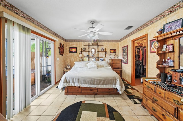 tiled bedroom featuring access to exterior, a spacious closet, a closet, and ceiling fan