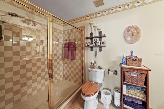 bathroom with walk in shower, toilet, tile patterned flooring, and a textured ceiling