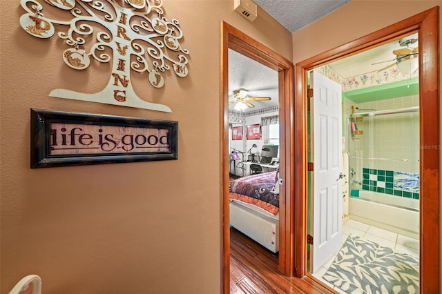 corridor featuring tile patterned floors and a textured ceiling