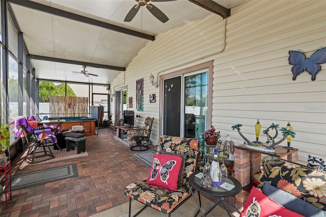 sunroom featuring ceiling fan and lofted ceiling with beams