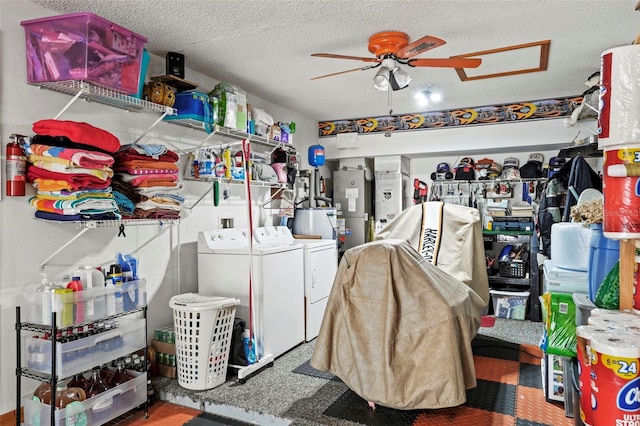 laundry room with water heater, ceiling fan, washing machine and clothes dryer, and a textured ceiling