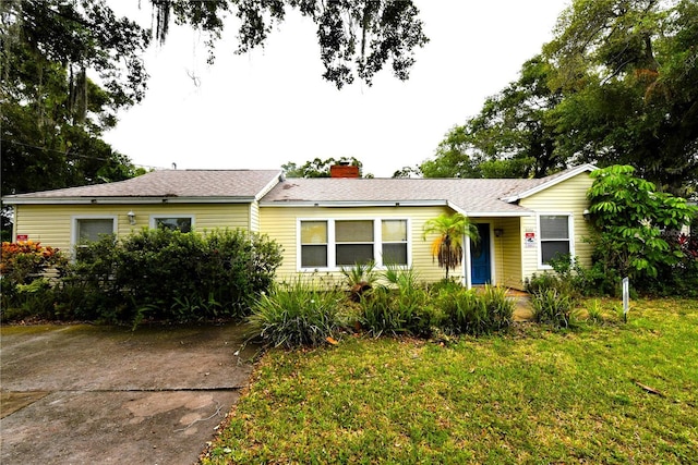 single story home featuring a front lawn