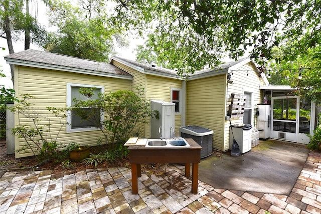 exterior space with a patio, a sunroom, and cooling unit