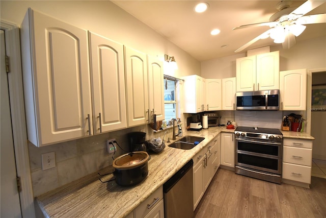 kitchen featuring appliances with stainless steel finishes, tasteful backsplash, white cabinetry, sink, and dark hardwood / wood-style flooring