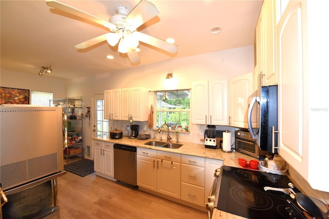 kitchen featuring stainless steel appliances, sink, light hardwood / wood-style flooring, and white cabinets