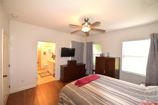 bedroom featuring connected bathroom, ceiling fan, and light wood-type flooring