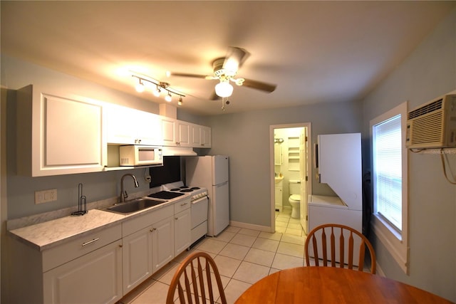 kitchen featuring white cabinetry, sink, light tile patterned floors, and white appliances