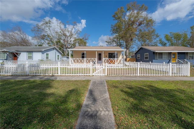 ranch-style home featuring covered porch and a front lawn