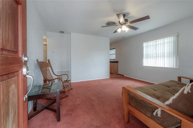 living area with ceiling fan and carpet flooring