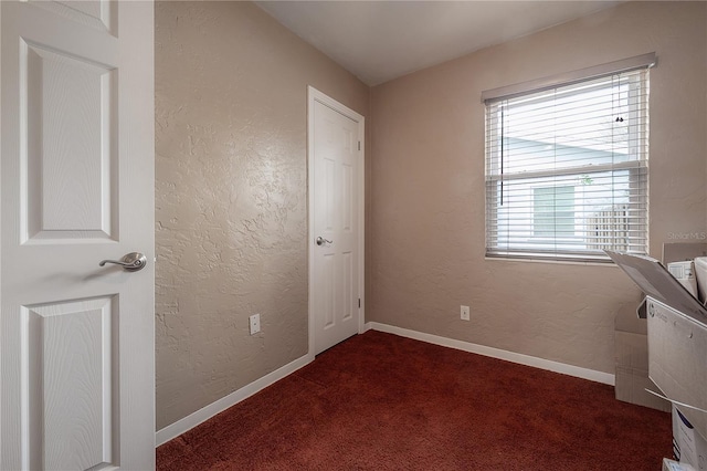 unfurnished bedroom with dark colored carpet