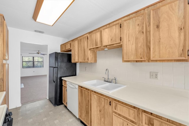 kitchen with light countertops, visible vents, freestanding refrigerator, a sink, and dishwasher