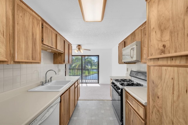 kitchen with white appliances, light countertops, a sink, and ceiling fan