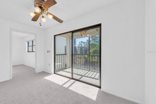 carpeted empty room with a ceiling fan and baseboards