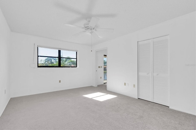 unfurnished bedroom featuring carpet floors, a closet, and a ceiling fan