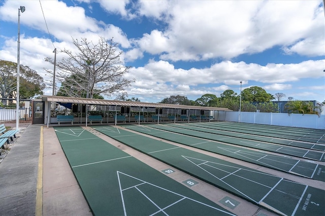 view of home's community with shuffleboard and fence