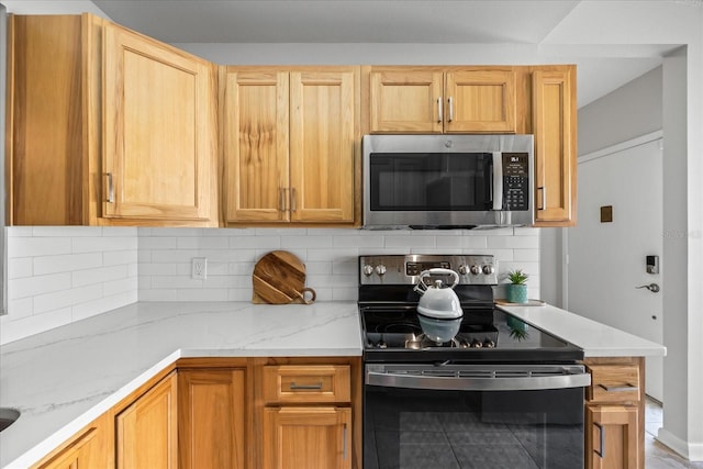 kitchen featuring light brown cabinetry, black range with electric stovetop, decorative backsplash, and light stone countertops