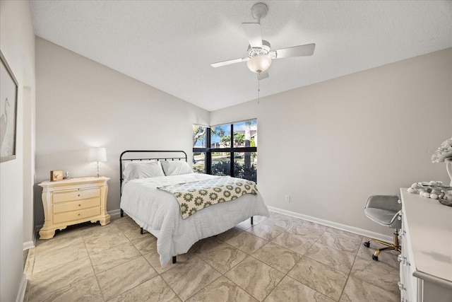 bedroom with vaulted ceiling, a textured ceiling, and ceiling fan