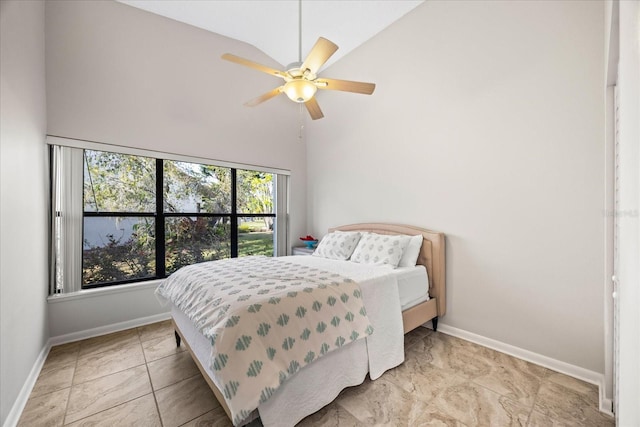 bedroom with ceiling fan and a towering ceiling