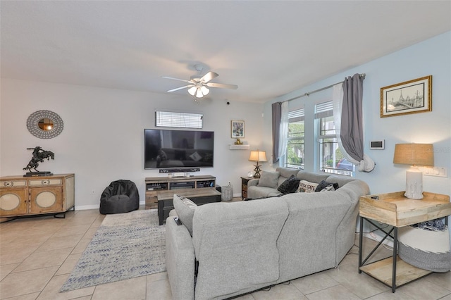 living area with ceiling fan, light tile patterned flooring, and baseboards