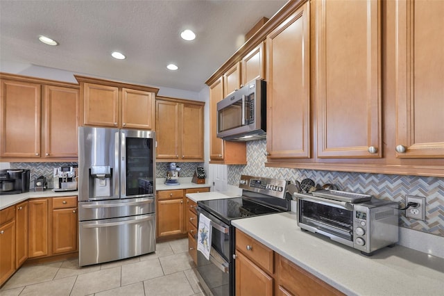 kitchen with stainless steel appliances, backsplash, light tile patterned flooring, recessed lighting, and brown cabinetry