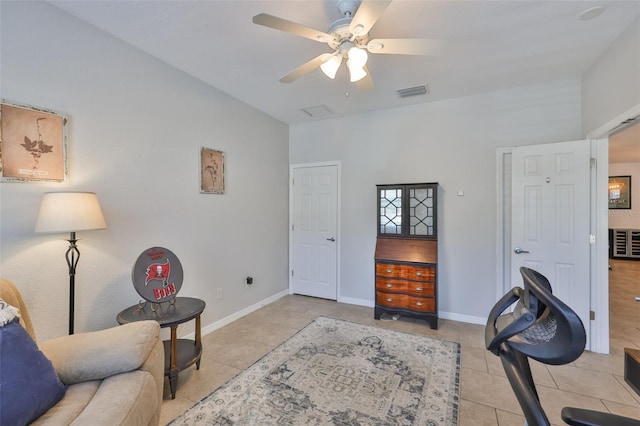 sitting room featuring light tile patterned floors, a ceiling fan, and baseboards