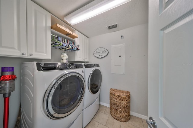 washroom featuring electric panel, washer and clothes dryer, cabinet space, baseboards, and light tile patterned floors