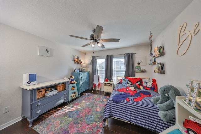 bedroom with dark wood-type flooring, baseboards, ceiling fan, and a textured ceiling