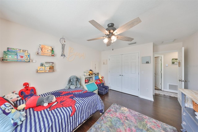 bedroom with wood finished floors, a closet, ceiling fan, and baseboards