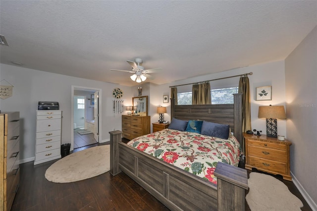 bedroom with dark wood-style floors, baseboards, a textured ceiling, a ceiling fan, and ensuite bathroom