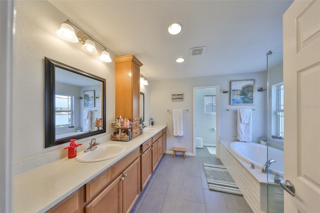 bathroom with a garden tub, double vanity, tile patterned flooring, recessed lighting, and toilet