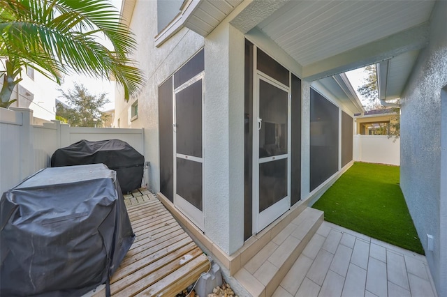 deck featuring fence, grilling area, and a sunroom