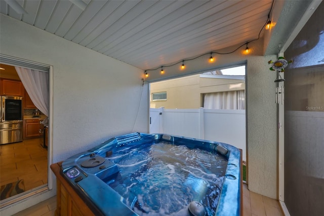 view of patio with a hot tub and fence