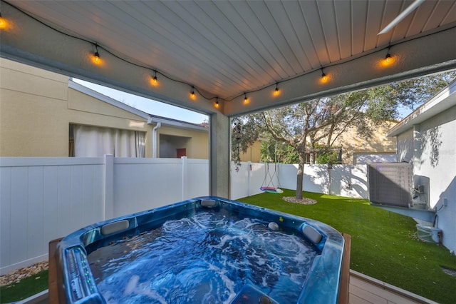 sunroom / solarium featuring a hot tub and track lighting