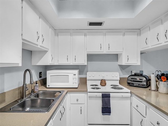 kitchen featuring white appliances, sink, and white cabinets