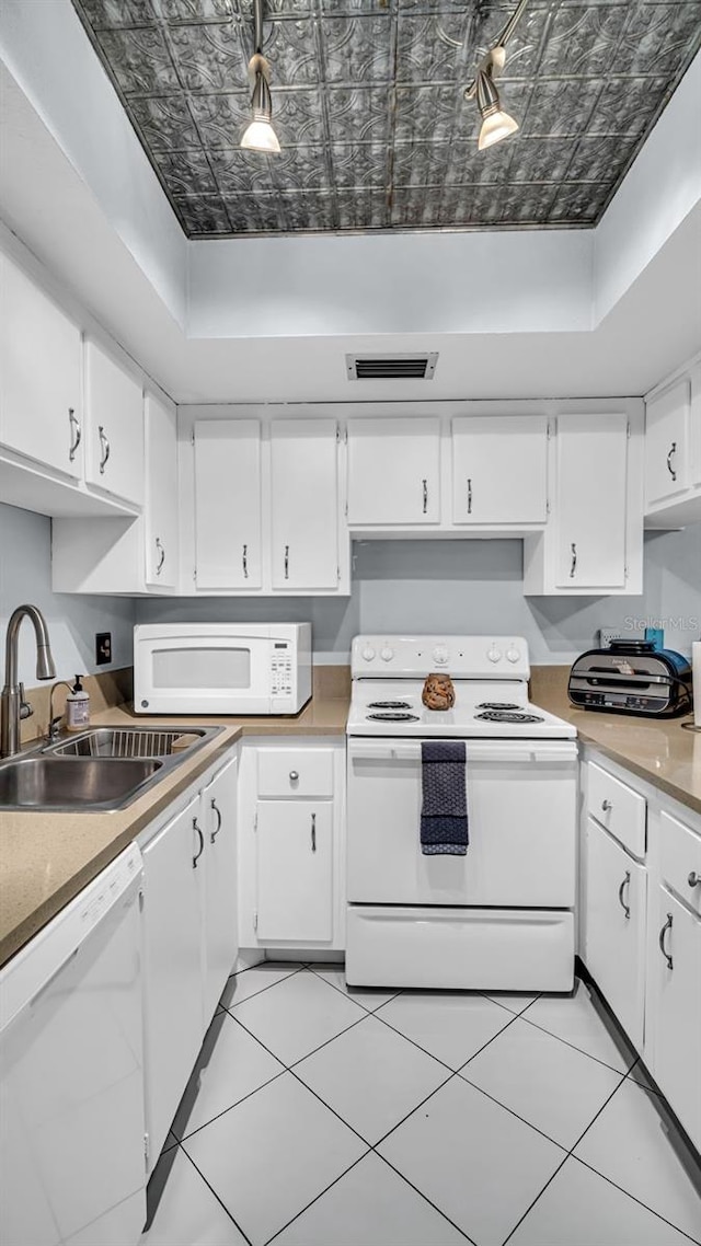 kitchen with white cabinetry, white appliances, sink, and light tile patterned floors