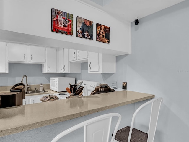 kitchen with white cabinetry, sink, and light stone counters