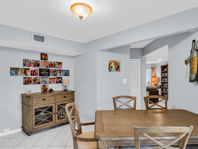 dining room featuring a textured ceiling and light tile patterned floors