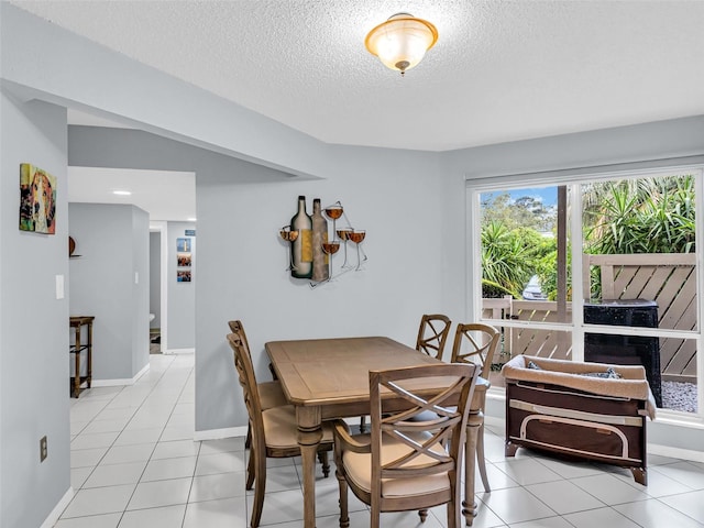 dining space featuring a textured ceiling and light tile patterned floors