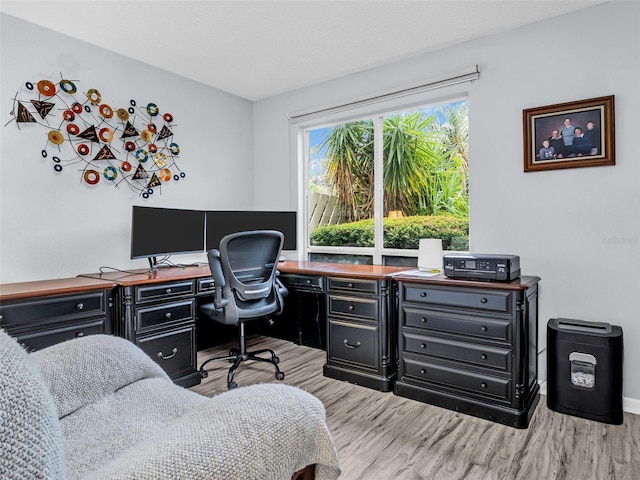 home office with light hardwood / wood-style floors