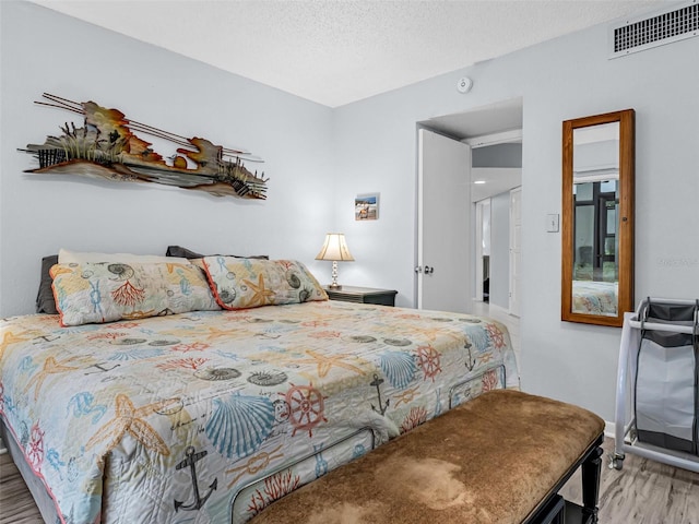 bedroom featuring a textured ceiling and light hardwood / wood-style floors