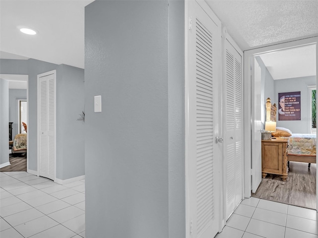 hallway with light tile patterned floors and a textured ceiling