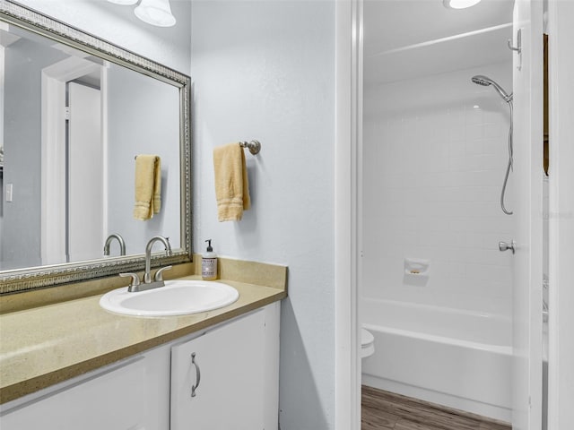 full bathroom with vanity, hardwood / wood-style flooring, toilet, and washtub / shower combination